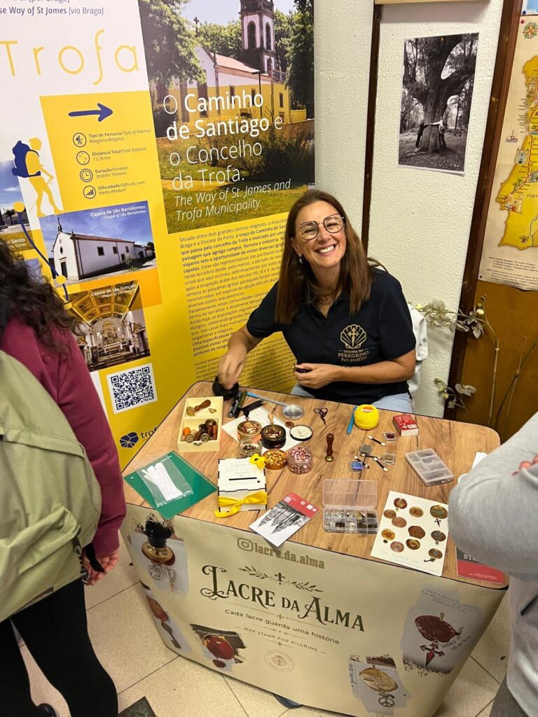 A volunteer at the Porto pilgrim office wearing the polo shirt with the golden scallop shell